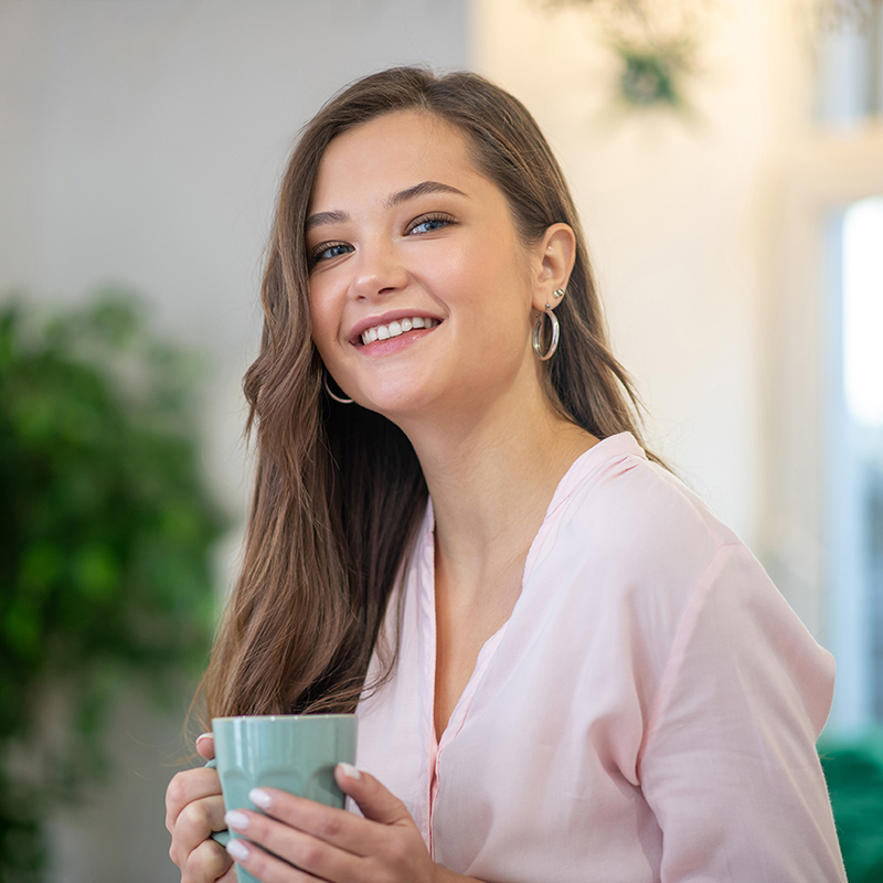 Full of energy. Face of a joyful young woman feeling full of energy while drinking coffee